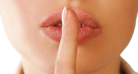 Frau legt Zeigefinger auf geschlossenen Mund; Detail-Aufnahme Mund und Finger