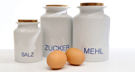 Zwei Eier vor geschlossenen Dosen zur Vorratshaltung für Salz, Zucker und Mehl